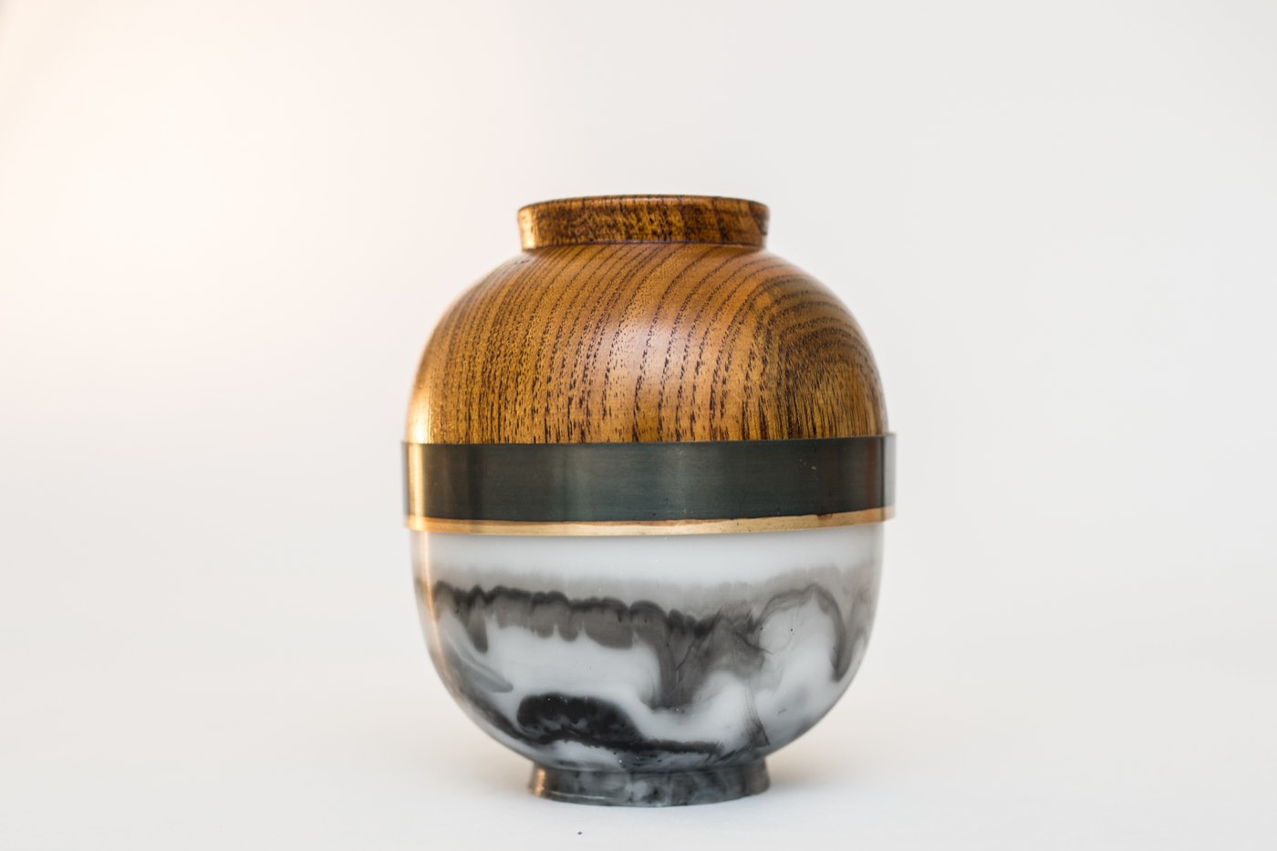 A turned vessel in wood, patinated brass and marbled resin
