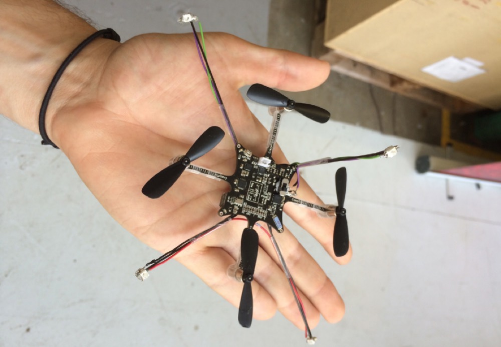 A small multi-rotor quadcopter resting on an open hand